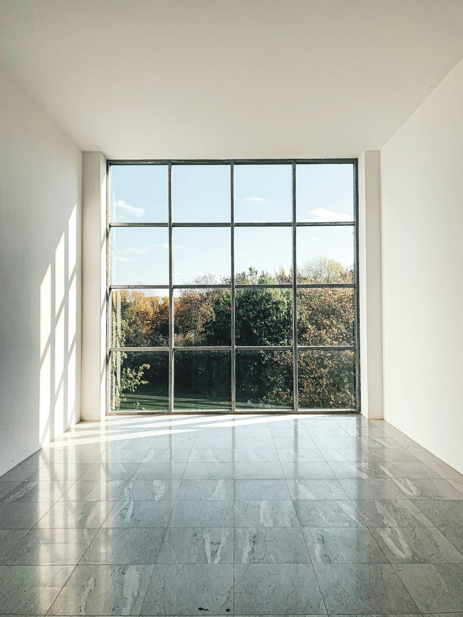 Großes Sprossenfenster mit Blick ins Grüne in einem hellen Raum
